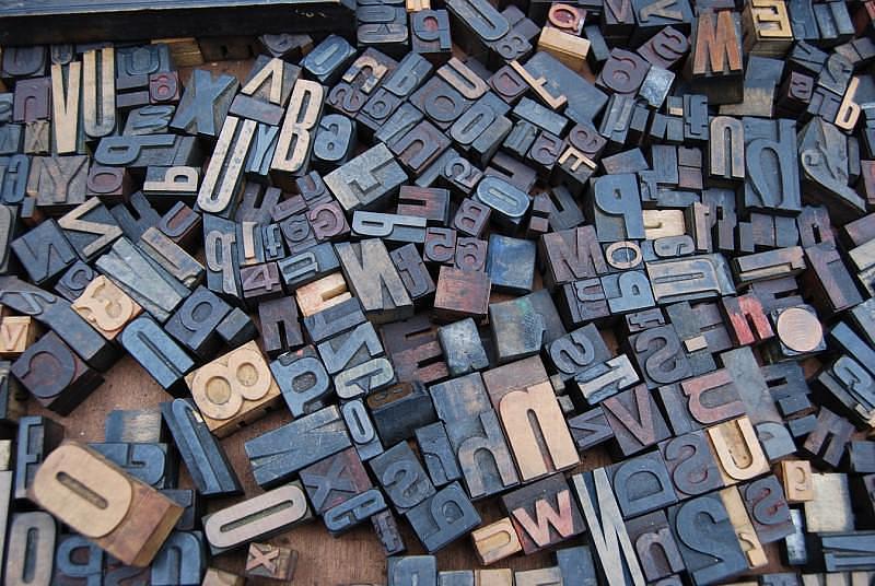 Different sized printing blocks of letters in a jumble